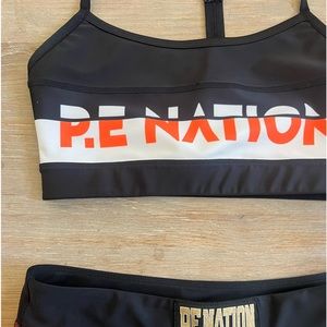 P.E Nation Orange white and black color block sports bra.